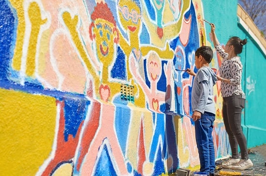 ICNL 2018-2019 Annual Report cover photo - mother and son paint a vibrant mural. (Photo: Caiaimage/Trevor Adeiline)