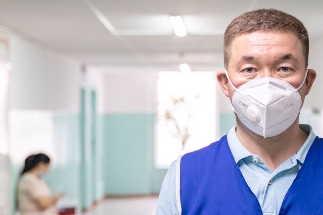 volunteer worker with mask in hospital hallway; COVID in Kyrgyzstan