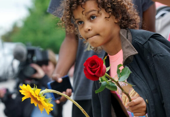 little girl with rose and sunflower in hand