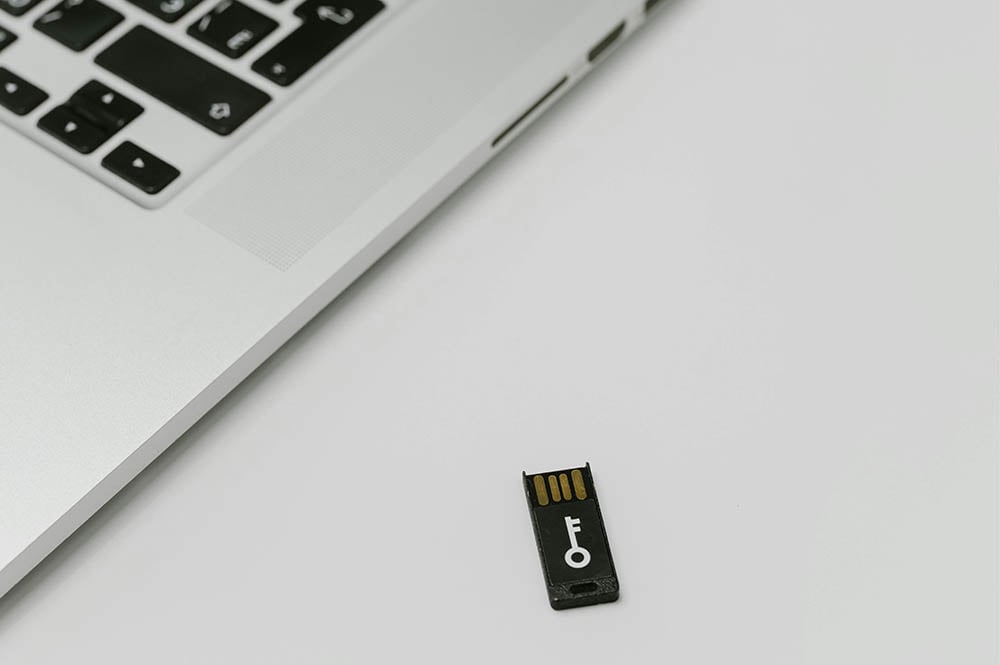 Image of an open laptop next to an SD card with a key printed on it