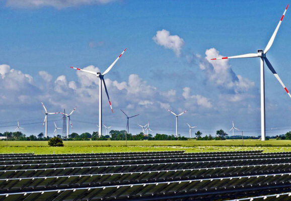 Solar panels, wind turbines, and an electricity pylon (Photo: hpgruesen/Creative Commons)