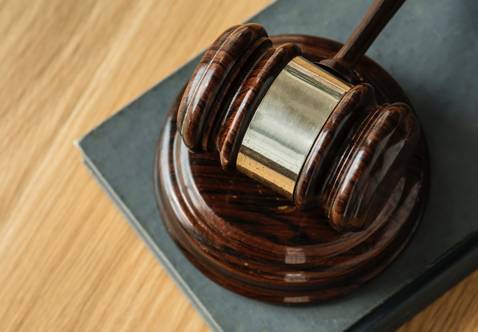 textbook for civil society organizations; Judges gavel laying on wood table (Photo credit: Rawpixel/Unsplash)