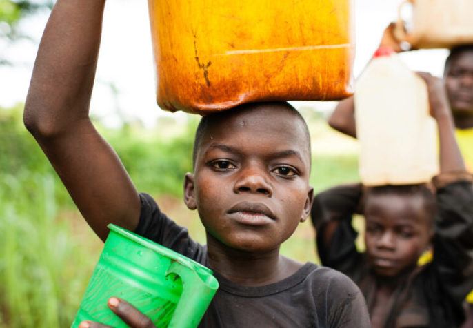 Donatien Voungoukpala, 13 (solid blue t-shirt), with his brothers Fleuri Rodrigue Hipai, 17, and Aime Bera-Mbolikia, 10, go to fetch water at a a nearby spring, their principle water source. August 20, 2012, Rounga Village, Bangassou, Central African Republic. Donatien and his family are IDPs who relocated to Bangassou from Rafai approximately one year ago as a result of the LRA conflict.