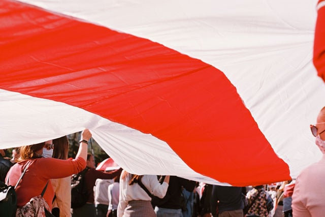 Laws in Belarus; Crowd Carrying Belarus flag (photo credit: unsplash.com)