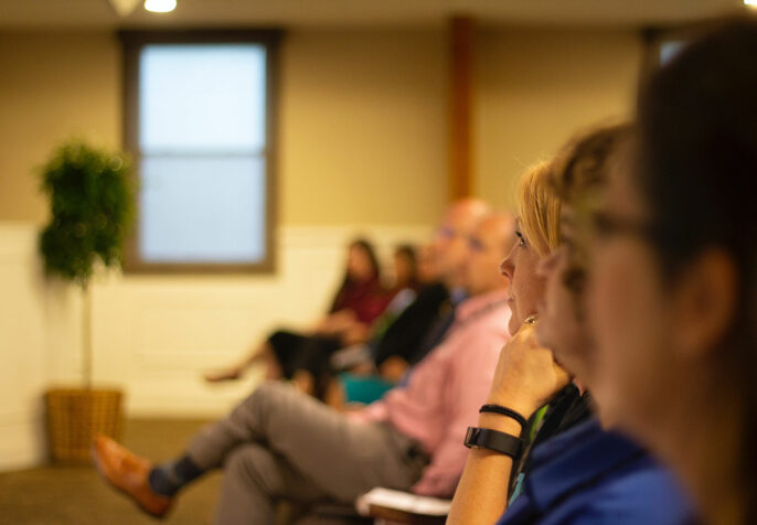 people listening to a speaker make an announcement