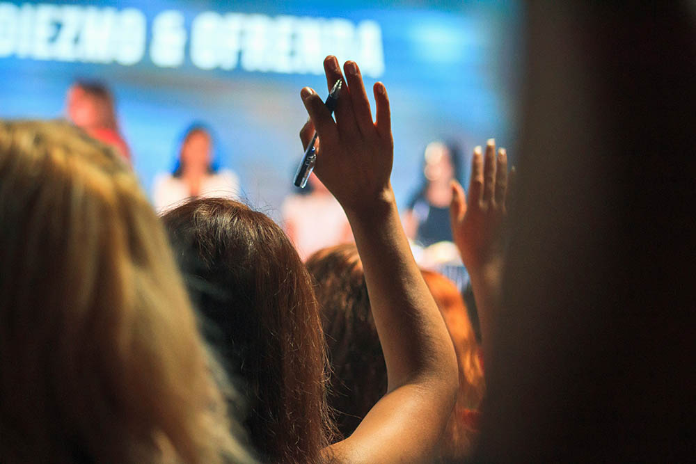 Woman raising her hand in a crowd
