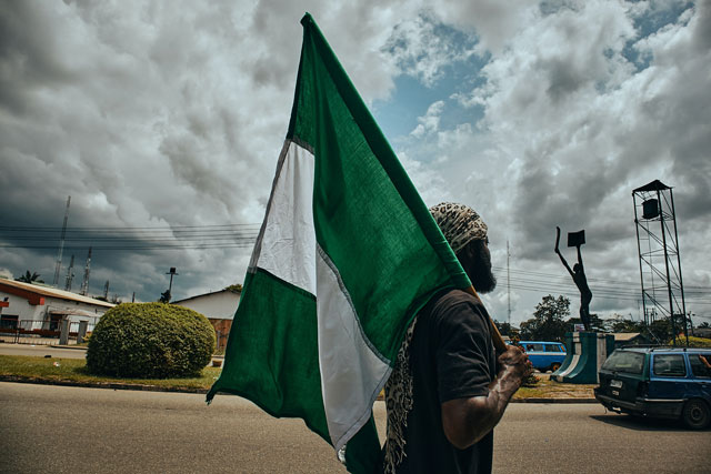 nigeria protester with flag (credit: unsplash.com)