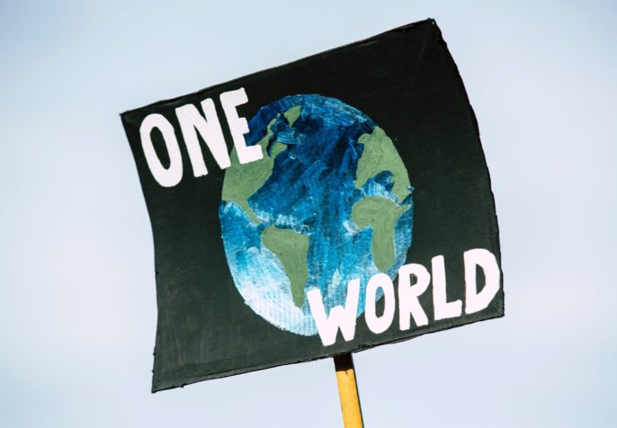 sign that says one world with Earth (photo credit: unsplash.com)